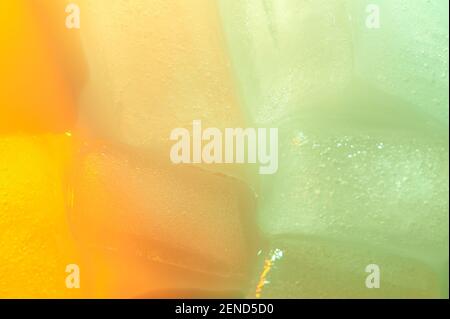 Wet melting ice background macro close up view orange and green color Stock Photo