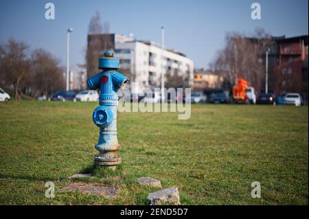 Traditional blue water pump with cityscape in background Stock Photo