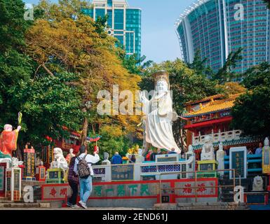 Hong Kong, China.  Repulse Bay.  Visitors at the Hong Kong Life Saving Society viewing its collection of sacred statues and images. Stock Photo