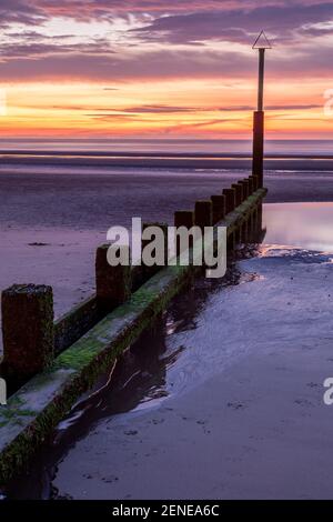 Sunset over Rhyl beach at low tide on the North Wales coast Stock Photo