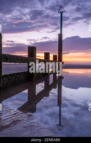 Sunset over Rhyl beach at low tide on the North Wales coast Stock Photo