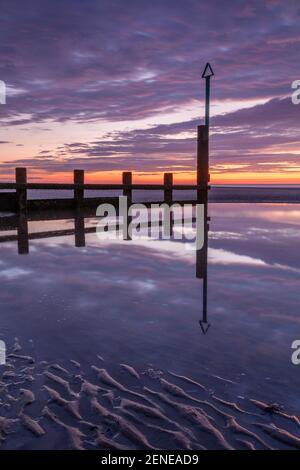 Sunset over Rhyl beach at low tide on the North Wales coast Stock Photo