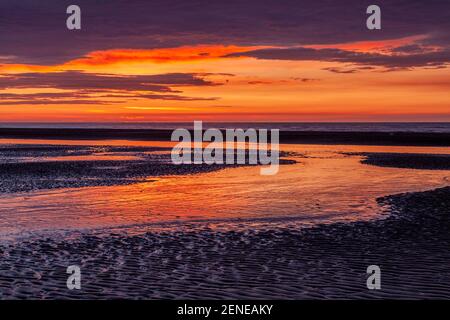 Sunset over Rhyl beach at low tide on the North Wales coast Stock Photo