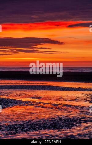 Sunset over Rhyl beach at low tide on the North Wales coast Stock Photo