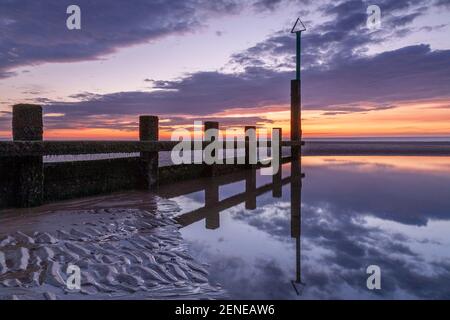 Sunset over Rhyl beach at low tide on the North Wales coast Stock Photo