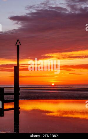 Sunset over Rhyl beach at low tide on the North Wales coast Stock Photo