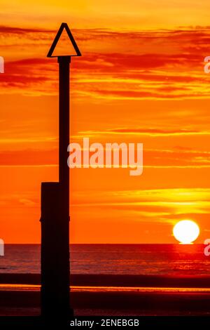 Sunset over Rhyl beach at low tide on the North Wales coast Stock Photo