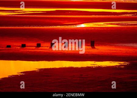 Sunset over Rhyl beach at low tide on the North Wales coast Stock Photo