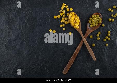 Canned corn seeds and green olives on black background Stock Photo