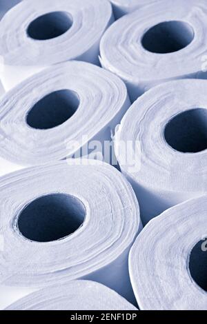 Closeup of toilet paper in monochrome blue. Symbolizing the shortage of supply due to the coronavirus pandemic. Vertical image. Stock Photo