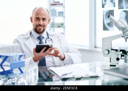 smiling young scientist works in a laboratory. Stock Photo