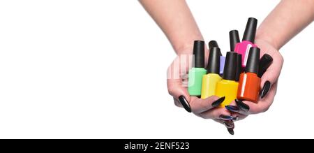 Female hands holds nail polishes bottles, isolated on white Stock Photo