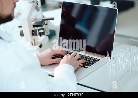 science lab technician using a laptop in the lab. Stock Photo
