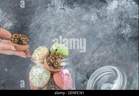 Female hand cookie jar. Female taking cookie from jar Stock Photo