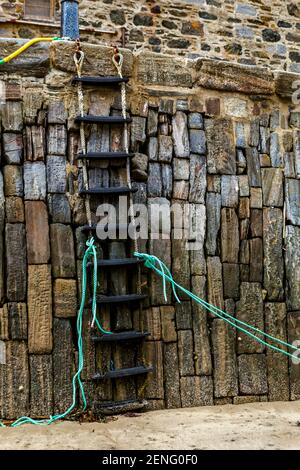 Rope ladder from jetty down into harbour. At low tide. Portsoy Banffshire Scotland UK Stock Photo
