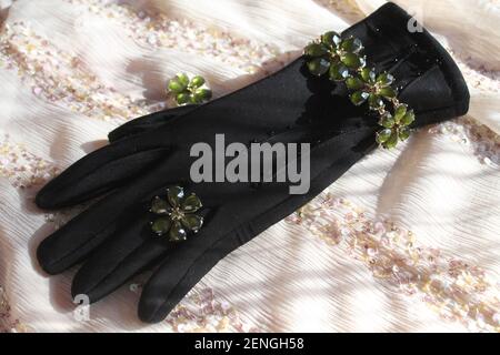 beautiful jewelry bracelet and ring in shape of daisy flower  lay on black woman's glove Stock Photo