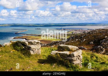 Scenic landscape of Irish Ferry terminal in port and coastline from Holyhead Mountain with ruin building in foreground. Holyhead Anglesey Wales UK Stock Photo