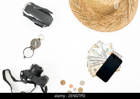 Travel concept with drone, straw hat, photo camera, vintage compass and usa cash on white background. Flat lay, top view. Stock Photo