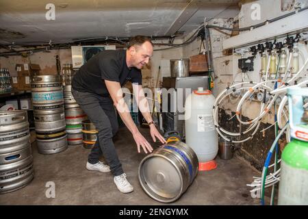 Sean Hughes landlord of 'Dylans' pub in St Albans prepares casks of beer for reopening his pub after the coronavirus lockdown#3 is lifted in England. Stock Photo