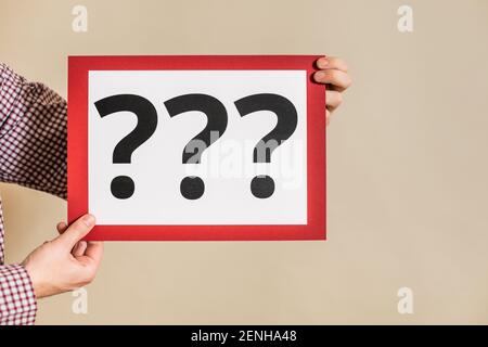Man showing paper with question marks. Stock Photo