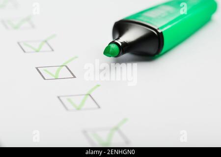 The green marker on the check sheet with markings in the form of ticks. Production concepts Stock Photo