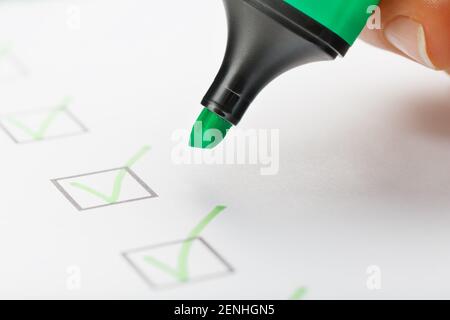The green marker on the check sheet with markings in the form of ticks. Production concepts Stock Photo