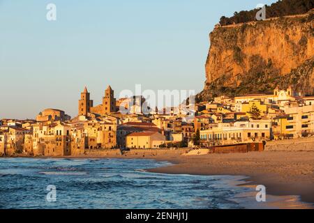 Italy,Sicily,Cefalu, the beach and surf with Cefalu  and Rocca in the background Stock Photo