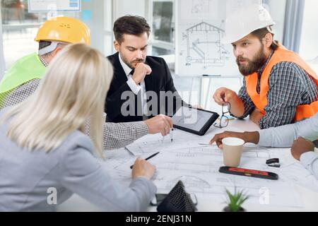 Multiracial office workers having meeting about construction Stock Photo