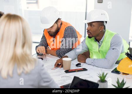 Multiracial office workers having meeting about construction Stock Photo