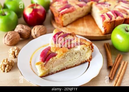 Piece of a tasty apple pie on a white plate, autumn baking concept. Homemade organic apple pie dessert ready to eat. Stock Photo