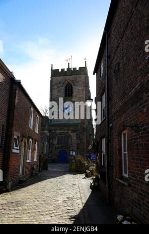 St Michael and all Angels Church as seen from the cobblestone street in Croston. Lancashire. Stock Photo