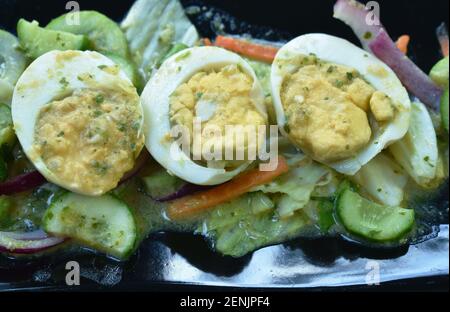 boiled egg half cutting tin sour and spicy salad on plate with fresh vegetable Stock Photo