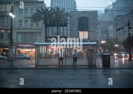 Passengers huddle under colorful umbrellas as they board the iconic New Orleans streetcar on a rainy day on bustling Canal Street. Stock Photo