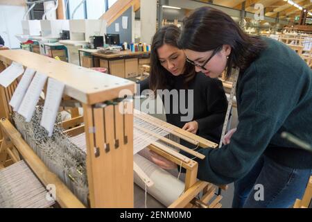 Students weaving with loom in textile workshop Stock Photo