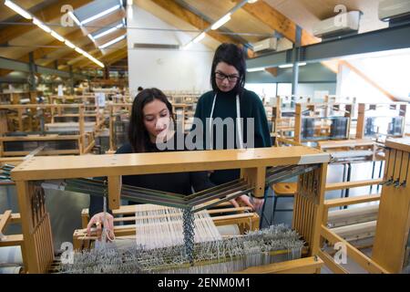 Students weaving with loom in textile workshop Stock Photo