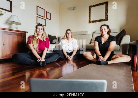 Female friends taking online exercise class Stock Photo