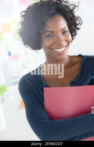 Portrait of woman holding file in office Stock Photo