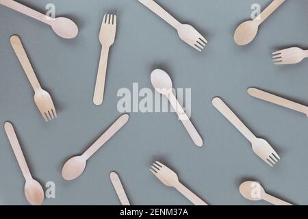Texture of disposable bamboo spoons and forks on gray background. Zero waste, plastic free concept. Top view, flat lay. Stock Photo