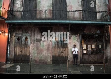 A musician outside the iconic Preservation Hall in New Orleans' French Quarter, embodying the city's rich jazz heritage and timeless charm. Stock Photo