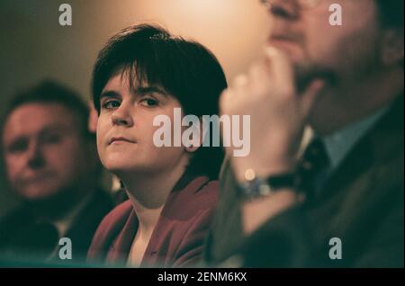 The Scottish National Party's Nicola Sturgeon listening to her party leader Alex Salmond addressing the media at the launch of the SNP's 1999 manifesto for the Holyrood election campaign in Edinburgh, Scotland. Ms Sturgeon was elected to the newly-created Scottish parliament in 1999 and went on to serve as the country's Deputy First Minister under Alex Salmond MSP and then as First Minister. At the time of the 1999 election she was working as a solicitor in the Drumchapel Law and Money Advice Centre in Glasgow. Stock Photo