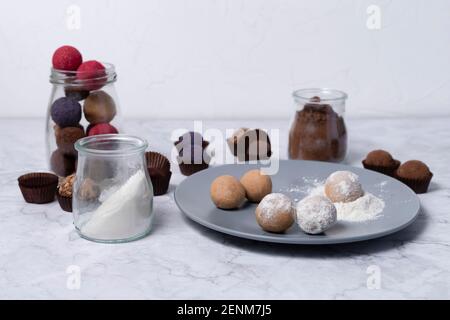 colored homemade energy balls - truffles made of cocoa, blueberry and beetroot powder. on a marble background Stock Photo