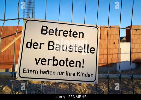 Sign on a fence with the inscription do not enter the construction site, parents are liable for their children Stock Photo