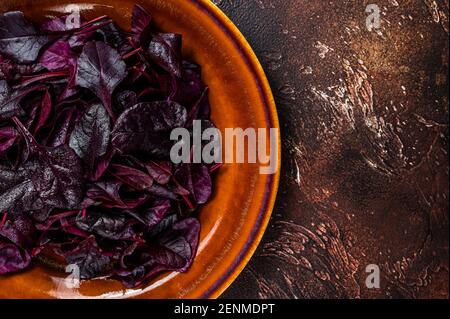 Raw Ruby or red chard salad Leafs on a rustic plate. Dark background. Top view. Copy space Stock Photo