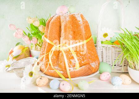 Easter sweets and decorations background, Sweet easter cake panettone with colorful painted eggs, spring grass and decor, copy space for text Stock Photo