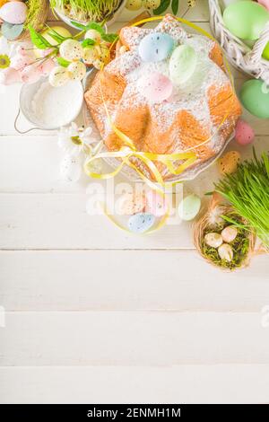 Easter sweets and decorations background, Sweet easter cake panettone with colorful painted eggs, spring grass and decor, copy space for text Stock Photo