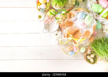 Easter sweets and decorations background, Sweet easter cake panettone with colorful painted eggs, spring grass and decor, copy space for text Stock Photo