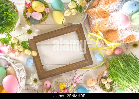 Easter sweets and decorations background, Sweet easter cake panettone with colorful painted eggs, spring grass and decor, copy space for text Stock Photo