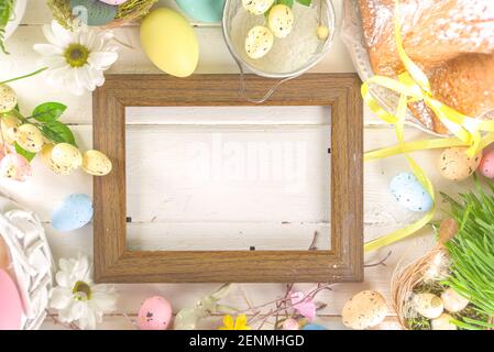 Easter sweets and decorations background, Sweet easter cake panettone with colorful painted eggs, spring grass and decor, copy space for text Stock Photo