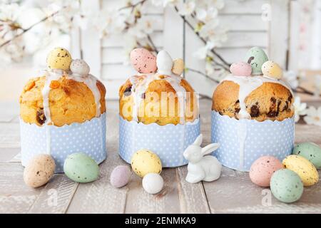 Little panettone cakes with sugar frosting and easter eggs Stock Photo