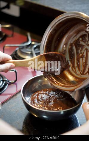 Typical Brazilian dessert called Brigadeiro. Home made with cocoa and condensed milk. The focus of the photo is on the bottom of the pan. Soft focus. Stock Photo